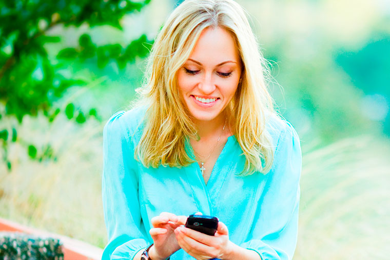 woman in sunlight on her mobile phone